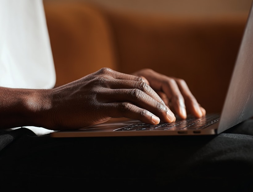 Primo piano di una persona che digita su un laptop.